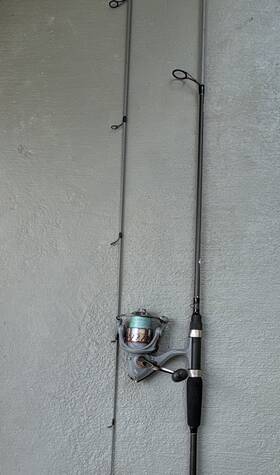 Ozark Trail Y6630m-2 3000 Size Spinning Reel Resting On A 6 Inch 2 Piece Medium Action Rod